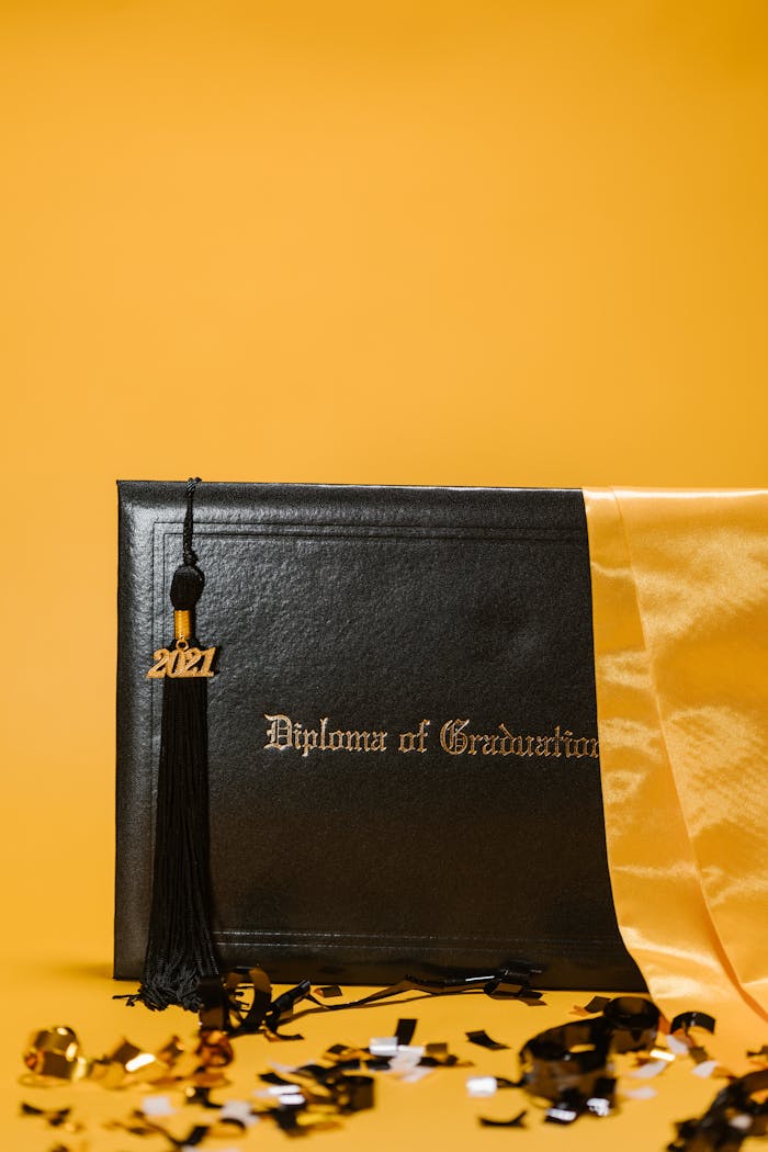 Close-up of a graduation diploma with a 2021 tassel, on a vibrant yellow backdrop.